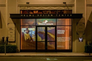 Photograph of Helms Design Center windows showing exhibition Projecting Possibilities and featuring artist Alexey Steele including artwork, artist image, and artist description 