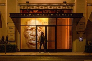 Photograph of Helms Design Center windows showing exhibition "Projecting Possibilities" and featuring artist Alexey Steele including artist and portrait artwork 