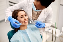 Woman in the dentist chair with dentist looking at her teeth