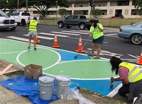 Asphalt art design treatment being applied to street.