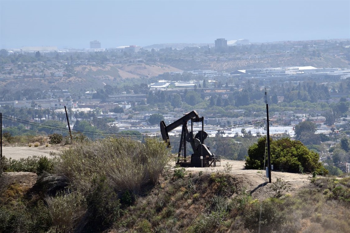 Photo of oil derrick pump in Inglewood Oil Field with Los Angeles in the background