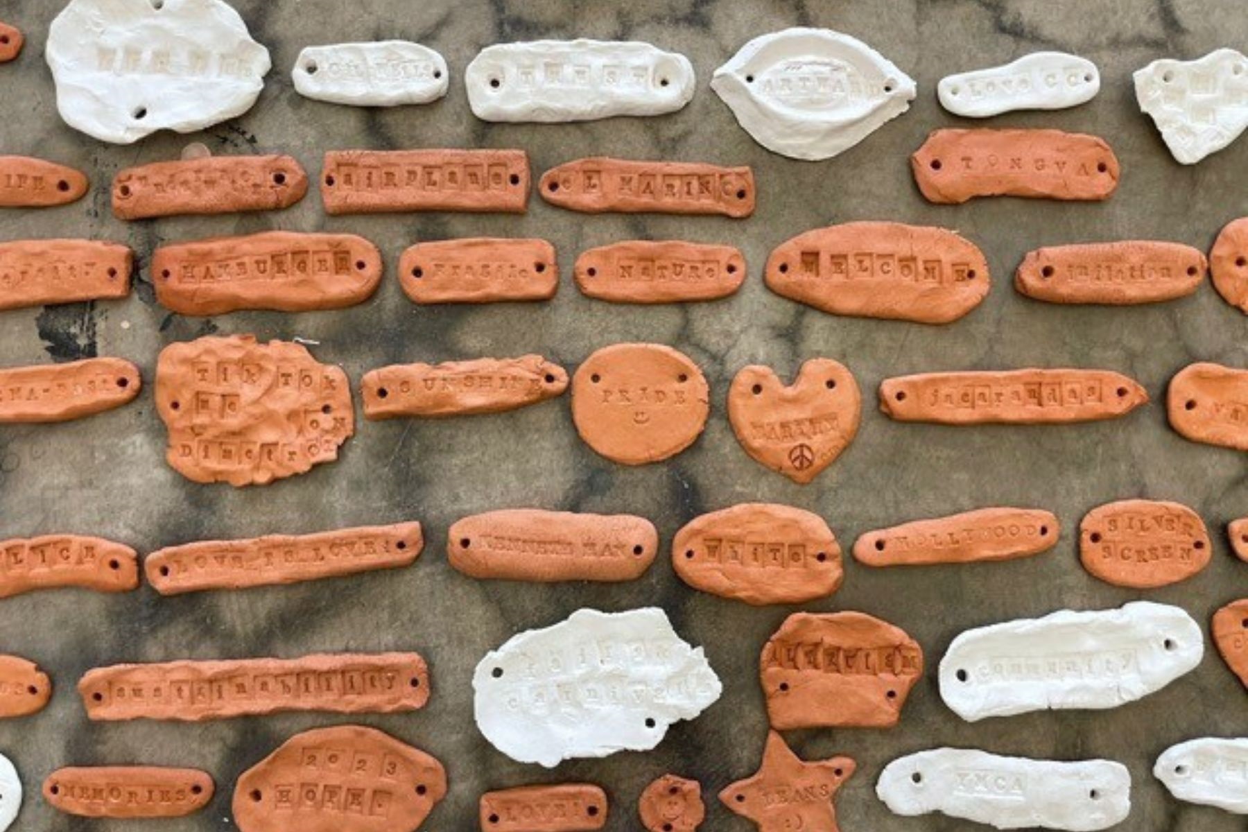 Photo of clay pieces with words stamped on them