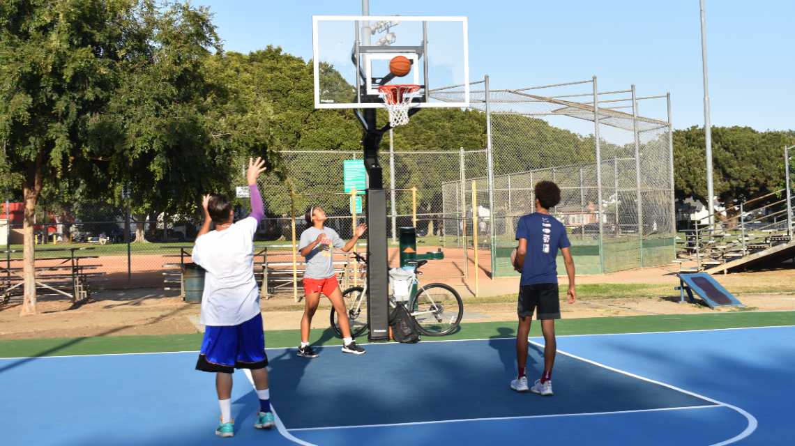Trio of Young Adults Playing Basketball at Vets Park