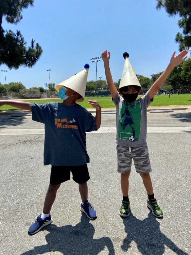 Two kids with pointy hats pose at Camp