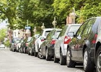 Photograph of many cars parking along residential street