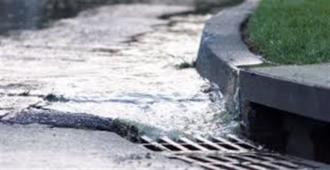 Photograph of stormwater running along street corner into storm drain